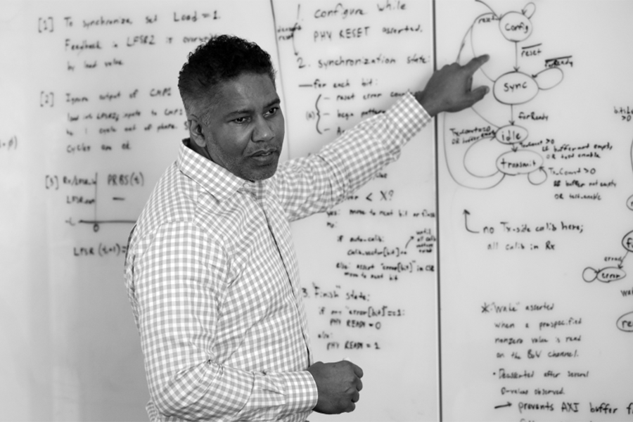 Blanton teaching a class in front of a white board.